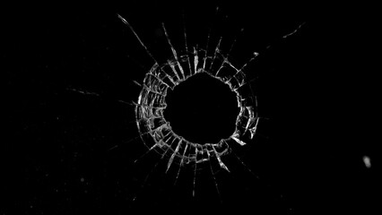 Close-up of gunshot through the glass, shattering against the black background