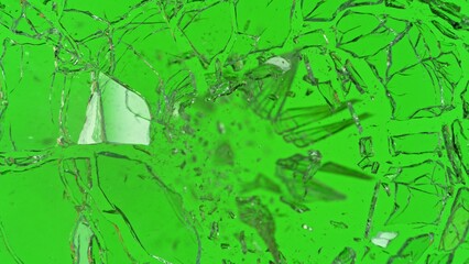 Close-up of gunshot through the glass, shattering against the green background