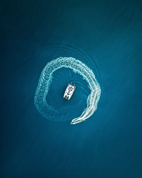Aerial view of beautiful blue ocean with speedboat creating waves, Whitsundays, Australia.