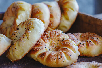 Close-up of freshly baked traditional Uzbek bread topped with sesame seeds, golden brown and soft, arranged in a bakery display setting. Tashkent, Uzbekistan