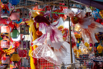 People in front of traditional colorful lanterns hanging on a stand in Hang Ma street, Hanoi city,...