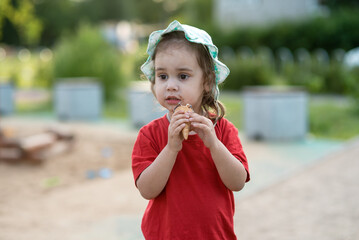 Little girl eating ice cream in the park in summer. Close-up portrait of a child