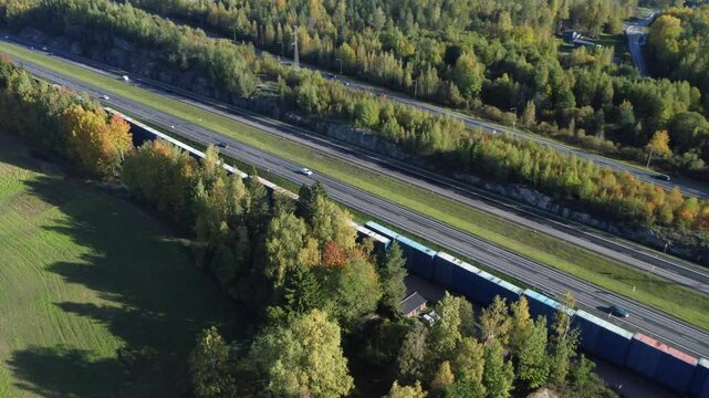Aerial rotates over divided highway in autumn, northern boreal forest