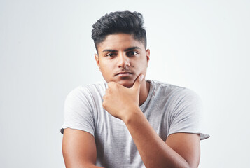 Indian man, portrait and fashion with casual style, tshirt or hairstyle in studio on a white background. Young, male person or handsome gen z model with serious face, confidence or cool attittude