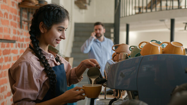 Arabian woman girl waitress barista in apron making cup fresh coffee in cafeteria indian female waitstaff service staff bartender serving customers make hot cappuccino bar counter in cafe restaurant - Powered by Adobe