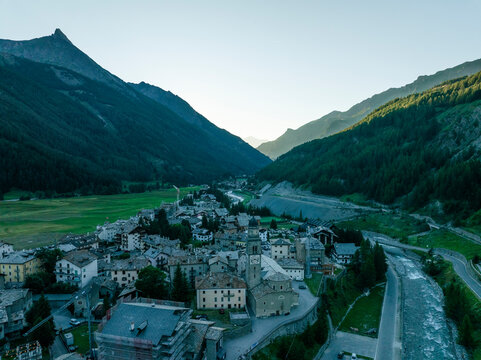 Aerial view of a picturesque village nestled in a tranquil valley surrounded by beautiful mountains and a serene river, Cogne, Aosta Valley, Italy.