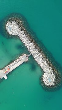 Aerial view of the beautiful Port des Sablettes with turquoise water and a breakwater, Menton, France.