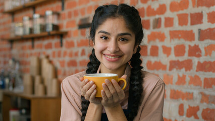 Young happy arabian woman enjoy fragrant drink in cafe smiling relaxed Indian girl restaurant...