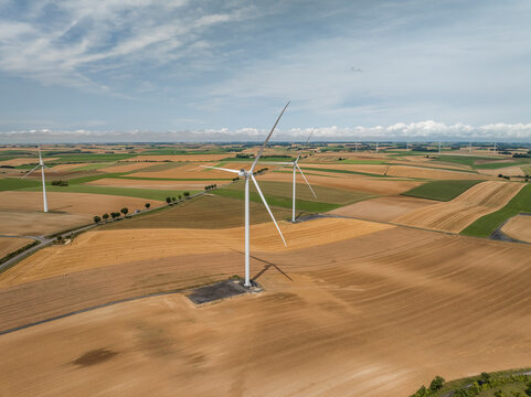 Aerial view of wind turbines over green fields under a cloudy sky, Son, Ardennes, France.