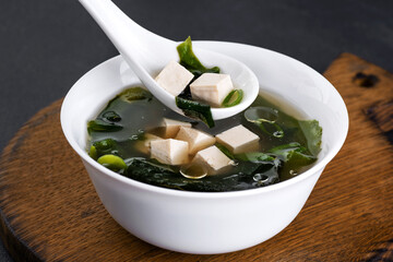 Seaweed soup with tofu on wooden board.
