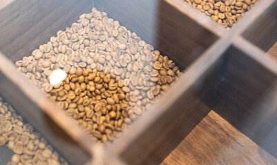 coffee beans showcase in a  wooden box sealed with glass,texture and background,light roasted and dark roasted beans,coffeeshop and culture