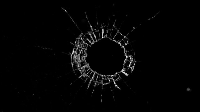 Super slow motion of gunshot through the glass, shattering against black background . Filmed on high speed cinema camera, 1000 fps.