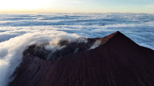 Aerial view of Kerinci Volcano crater above the clouds, Sumatra, Indonesia.