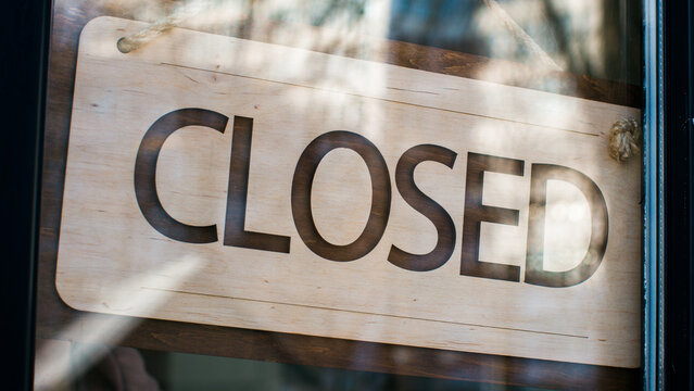 Close-up man waiter salesman turning signboard from closed to open on glass door male restaurant owner seller manager opens cafe shop businessman entrepreneur opening new store small business concept