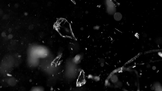 Super slow motion of gunshot through the glass, shattering against black background . Filmed on high speed cinema camera, 1000 fps.