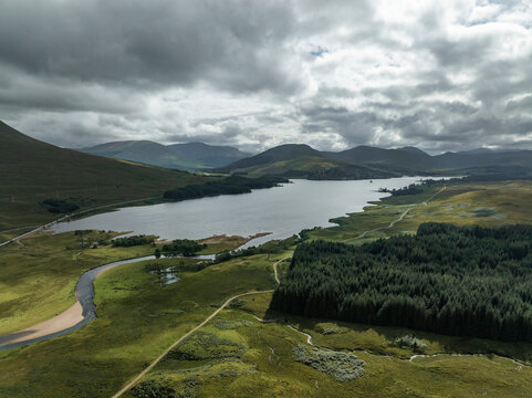 Aerial view of serene Loch Tulla surrounded by majestic mountains and lush greenery, Bridge of Orchy, Scotland.