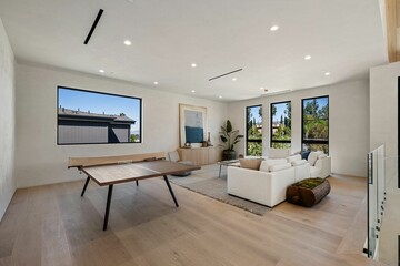 Modern living room with minimalist decor and large windows.