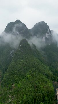 Aerial view of majestic mountains and lush forests shrouded in mist, Guilin, China.