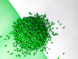 Green masterbatch granules on a white and green background. Color pigment carrier polymer in the...