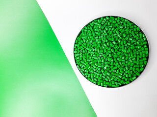 Green masterbatch granules on a white and green background. Color pigment carrier polymer in the...