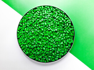 Green masterbatch granules on a white and green background. Color pigment carrier polymer in the...