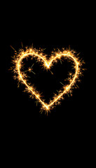 Fototapeta premium golden bright sparkler heart shape love shaped symbol isolated dark black background. silvester new year birthday wedding and celebration design pattern isolated with white highlights, png