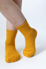 Baby feet in yellow socks on a white background