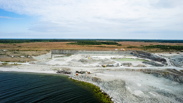 Aerial view of polluted beach and mining industry with excavator and soil, Oland Island, Sweden.