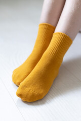 Baby feet in yellow socks on a white background