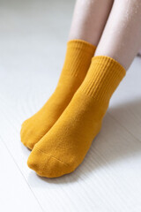 Baby feet in yellow socks on a white background