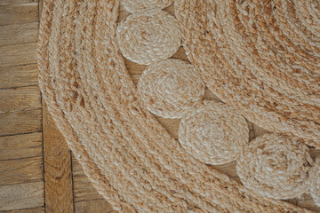 Detailed woven jute rug displayed on wooden flooring in natural light