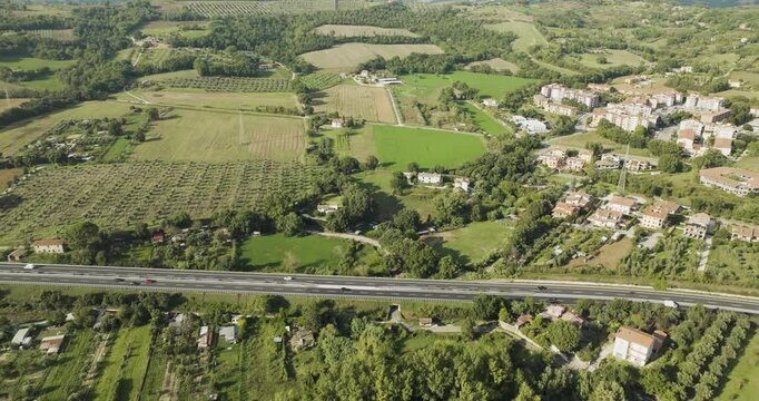 Aerial view of beautiful countryside with highway, fields, village, and homes, Orte, Italy.