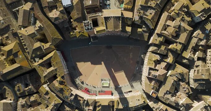 Aerial view of historic Piazza del Campo surrounded by beautiful medieval buildings and rooftops, Siena, Italy.