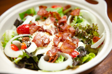 Salad with bacon and cheese and Caesar dressing