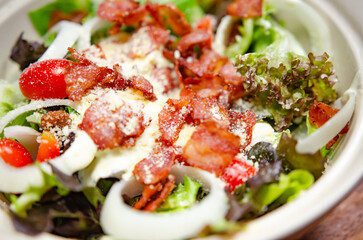 Salad with bacon and cheese and Caesar dressing