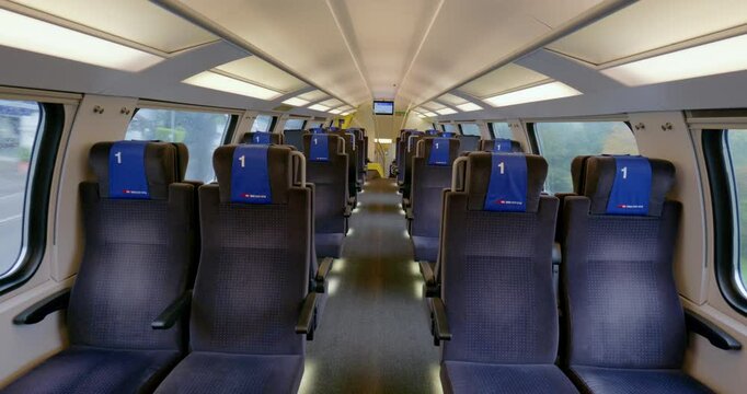 14-10-2024 SBB national railway, Switzerland. Empty first class row's of bench seats inside moving public passenger train in Switzerland. Wide angle view, between seat corridor, standing up point of v