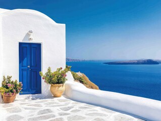Fototapeta premium A picturesque view featuring a blue door, white-washed walls, and vibrant plants overlooking a serene sea and clear skies.