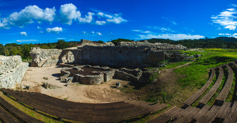 Naklejka premium the ancient ruins of a Roman amphitheater in a bright and open landscape.