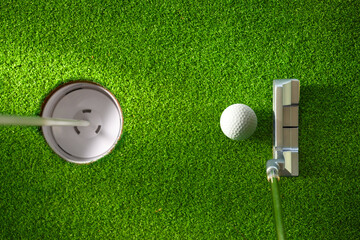 Top view of golf ball and putter ready putting to golf hole.