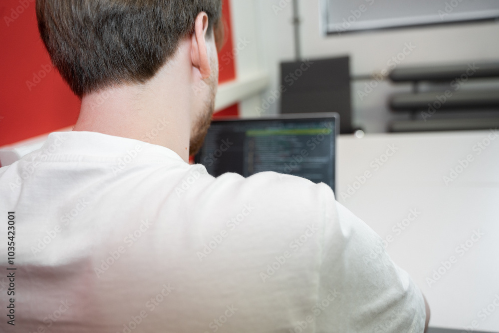 Poster a skilled it specialist is focused on programming in a modern coworking environment. he is working i