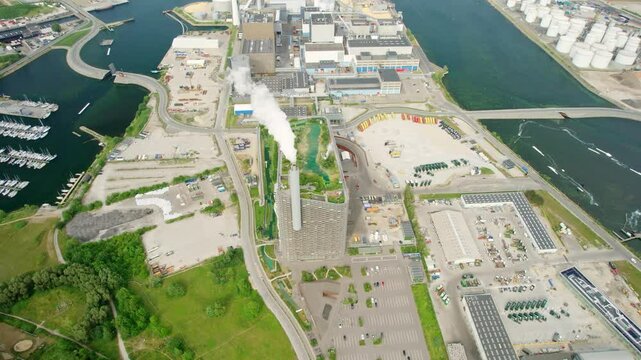 Aerial view of copenhill power plant with wind turbines and boats in the harbour, copenhagen, denmark.