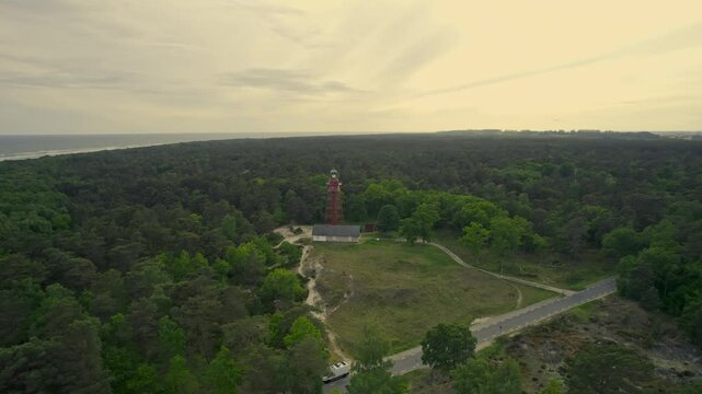 Aerial view of serene lighthouse surrounded by tranquil forest and ocean, Karlshamn Citadel, Sweden.