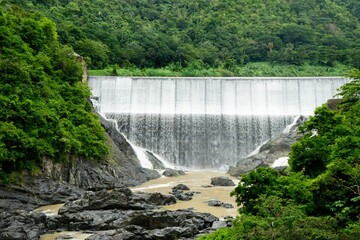 Scenic view of a dam with flowing water, surrounded by lush green trees. Comerio, Puerto Rico
