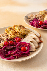 A wholesome plate featuring green buckwheat, chicken breast and zucchini pancakes paired with fermented vegetables