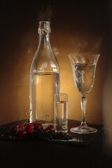 Ripe cherries next to glass, shot, and goblet. The triangle of light creates a dramatic effect on the dark backdrop, highlighting the freshness