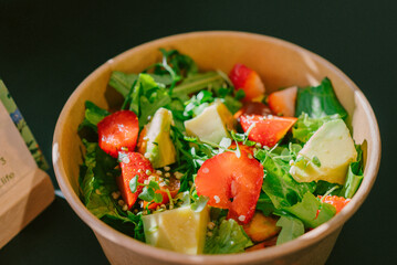 Vibrant salad with fresh strawberries, avocado, and greens in a compostable bowl, perfect for vegan and vegetarian diets. Enjoy this sustainable dish promoting clean eating