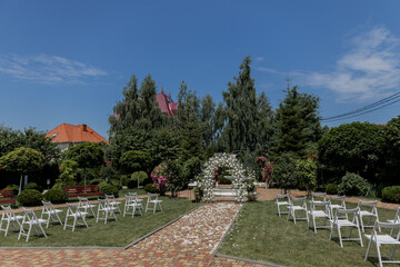 a beautiful arch for a wedding ceremony in a park with chairs