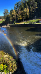 Rainbow on a river dam with falling water. Bobr River, Poland. © PRO Balance