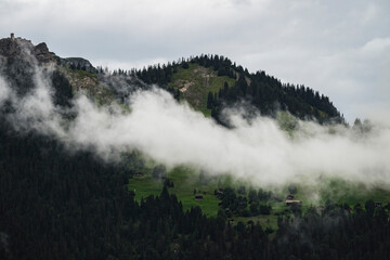 View of majestic Bernese Alps with fog and greenery, Lauterbrunnen, Switzerland.