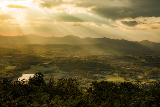 View of breathtaking sunset over majestic mountains and serene valley with lush trees, Virginia, United States.